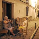 Unas mujeres, al anochecer en una acera de Ronda (Málaga), tras la caída del sol