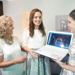 Alicia, junto a su hermana y su madre, sostienen el ordenador a través del cual se comunica su padre desde Colombia