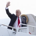 Donald Trump saluda a bordo del Air Force One, hoy sábado, en la base aérea de Andrews.