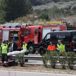 Miembros de los servicios funerarios trasladan a uno de los fallecidos en el accidente ocurrido hoy en la autopista AP-7.