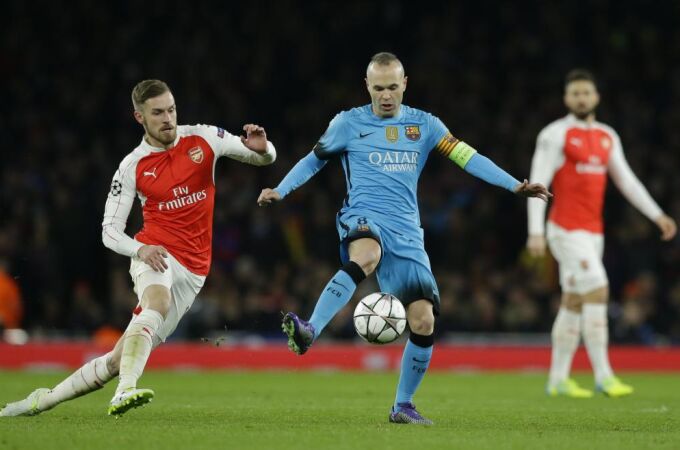 Aaron Ramsey pelea por el balón con Andrés Iniesta