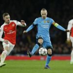 Aaron Ramsey pelea por el balón con Andrés Iniesta