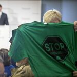 Una activista de la PAH muestra una camiseta alusiva a los deshaucios durante la intervención de Rajoy