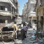 Varios civiules caminan entre los escombros en la ciudad de Jouret Al Chyah el pasado domingo