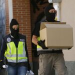Agentes de la Policía Nacional tras concluido el registro de la casa del supuesto yihadista detenido en la localidad madrileña de San Martín de la Vega