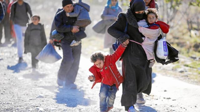 Un grupo de refugiados corren hacia la frontera con Serbia en la localidad macedonia de Gevgelija