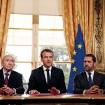 El presidente francés Emmanuel Macron atiende a los medios junto al ministro de Interior Gerard Collomb (izda), y al portavoz del Gobierno, Christophe Castaner, tras la firma de una nueva ley antiterrorista en el Palacio del Elíseo