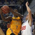 El base esloveno del Real Madrid Luka Doncic (d) defiende el ataque del estadounidense Bo McCalebb, base del Herbalife Gan Canaria