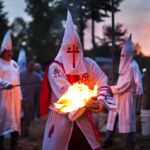 Un miembro de la orden de los Caballeros de la Brigada Rebelde del Ku Klux Klan (KKK) enciende una antorcha durante una ceremonia en una propiedad privada en Martinsville, en el estado de Virginia (EE.UU.), el 2 de julio de 2011.