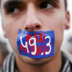Participantes de las concentraciones contra la reforma de la ley laboral protestan con un adhesivo con el 49.3 pintado