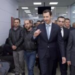 El líder sirio, Bachar al Asad (c) saludando a la gente durante la inauguración de la construcción de un proyecto en el barrio de Al-Mazzeh en Damasco