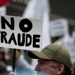 Decenas de ecuatorianos protestan frente al Consejo Nacional Electoral hoy, lunes 20 de febrero de 2017, a la espera de los resultados de los comicios generales en Ecuador.