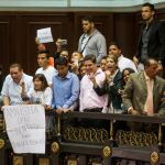 Familiares de presos políticos muestran afiches en el palco de invitados del hemiciclo de sesiones de la Asamblea Nacional hoy, jueves 4 de febrero.