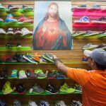 Un vendedor arreglando la mercancía en un puesto del mercado popular La Hormiga ubicado en el sur de Caracas (Ve