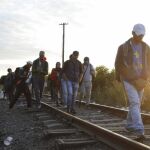 Inmigrantes caminan junto a una línea de tren que conecta a Horgos y Szeged en las proximidades de la frontera entre Hungría y Serbia, cerca a la frontera Roszke, a unos 180 km de Budapest