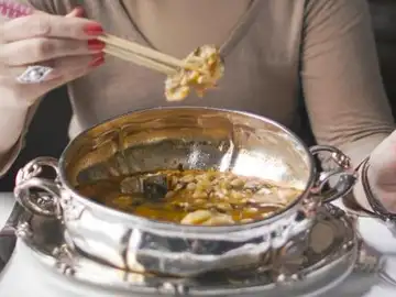 Una comensal degusta un potaje de vigilia Una comensal degusta un potaje de vigilia