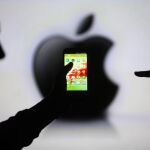 Un teléfono Samsung, sobre la silueta del logo de Appple