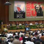Fidel Castr escucha a su hermano Raúl durante el congreso del PPC