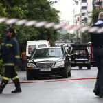 Miembros de los servicios de emergencias junto al coche del ex primer ministro griego Lucas Papademos.