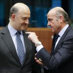 El comisario europeo de Asuntos Económicos, Pierre Moscovici, conversa con el ministro español en funciones de Economía, Luis de Guindos.