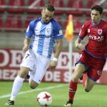 El delantero del Numancia Ignacio Agustín Sánchez (d) y el centrocampista del Málaga Javier Ontiveros durante el partido