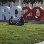 Jóvenes conversan en un parque junto a una zona de aficionados en la Place Bellecour de Lyon (Francia)