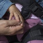 La manos de una madre y su hija, que padece una enfermedad rara
