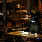 Un policía israel investiga en una cafetería del centro comercial