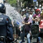 Manifestantes se enfrentan a los antidisturbios de los Mossos d'Esquadra, durante los incidentes producidos ayer en el barrio de Gràci