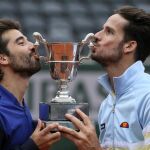 Feliciano López y Marc López besan el trofeo