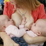 Una mujer da el pecho a sus gemelos en una ciudad rusa