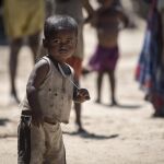 Un niño, que sufre de desnutrición, sostiene una cuchara en la ciudad de Amboasary, Madagascar