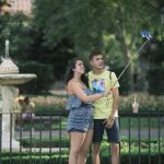 Dos turistas se hacen un selfie en un parque de Madrid
