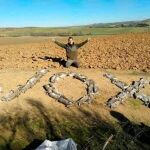 Un cazador con decenas de conejos muertos formando la palabra "Vox"