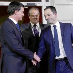Tras la batalla. Manuel Valls (izda.) y Benoît Hamon se dan anoche la mano a la entrada de la sede del Partido Socialista en París