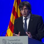 El presidente de la Generalitat, Carles Puigdemont, atiende a los medios de comunicación después de presidir la cumbre política y social en defensa de la ley de emergencia social frente al recurso del Gobierno central
