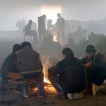 Varios refugiados se calientan junto a una hoguera en Belgrado ante las bajas temperaturas que sufre Europa.