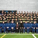 Los entrenadores y dirigentes españoles posan junto a la cantera de Evergrande en Madrid