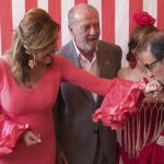 Susana Díaz, vestida de flamenca, junto al rector de la Universidad de Sevilla, Miguel Ángel Castro (d), y el presidente de la Diputación Provincial, Fernando Rodríguez Villalobos (c), en la caseta del ayuntamiento hispalense en la Feria de Abril de Sevilla.