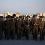 Militares norcoreanos ofrecen flores frente a las estatuas de bronce de Kim Il Sung y Kim Jong Il
