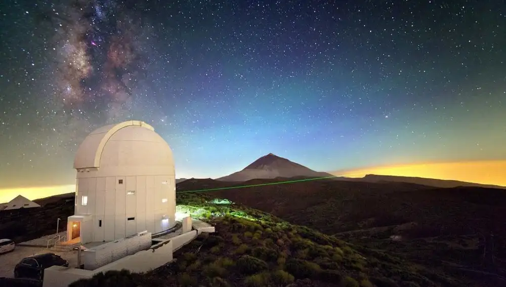Imagen cedida por Mario Krenn, investigador del Instituto de Óptica e Información Cuántica (IQOQI) de Viena, de una de las transmisiones de datos por láser realizadas desde la cumbre de La Palma hasta la de Tenerife, en la que se observa el haz de luz atravesando el cielo nocturno sobre la Caldera de Taburiente, con el Teide al fondo.