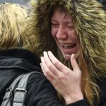 Una mujer se emociona mientras observa los ramos de flores mientras guarda un minuto de silencio en el Puente de Londres, cerca de Borough Market.