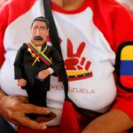 Una simpatizante del dictador sujeta una figurita de Nicolás Maduro