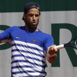 El tenista español Feliciano López golpea la bola contra su compatriota David Ferrer durante su partido de la segunda ronda de Roland Garros