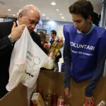Jorge Fernández Díaz colabora con los voluntarios de la recogida solidaria del Banco de Alimentos de Cataluña.