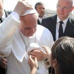 El Papa Francisco acepta el solideo que le ofrece una niña y, siguiendo la tradición, lo intercambia con el suyo