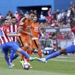 Los jugadores del Atlético de Madrid Koke Resurrección (i) y Thomas (d) disputa un balón con el delantero del Eibar Kike García