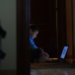 Un menor consultando su ordenador en casa