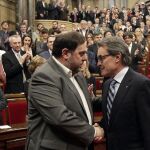 Mas saluda al presidente de ERC Oriol Junqueras poco antes de comenzar el pleno del Parlament.