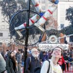 Una joven se sonríe ante uno de los números circenses que pueden disfrutarse en la plaza Cataluña